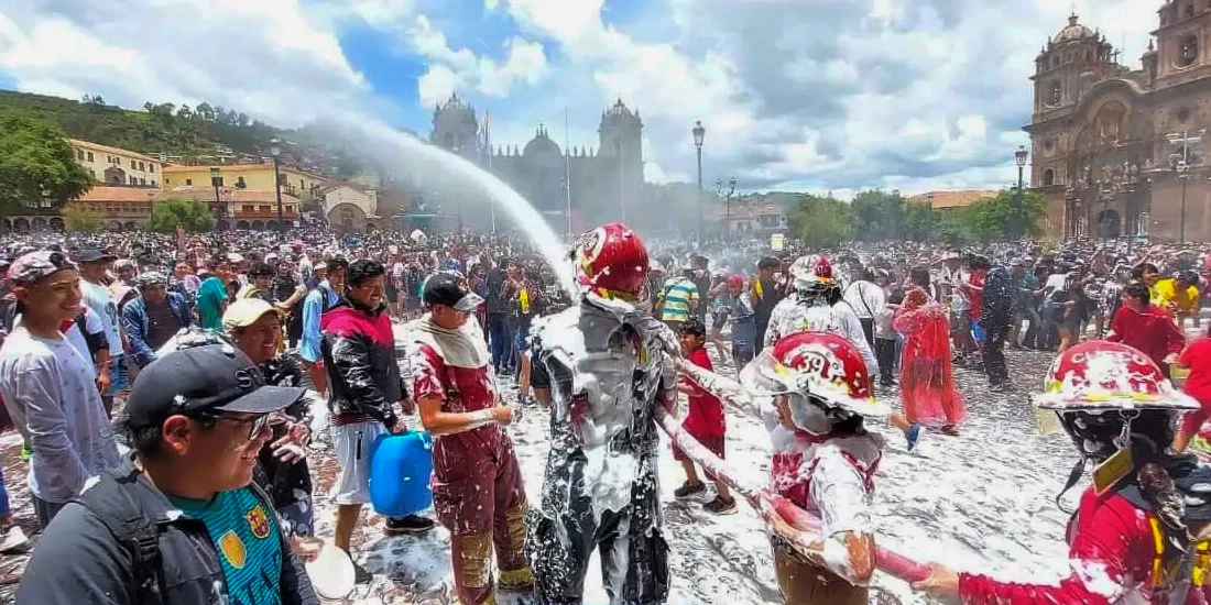 People playing with foam and water in the Plaza de Armas of Cusco during carnival.