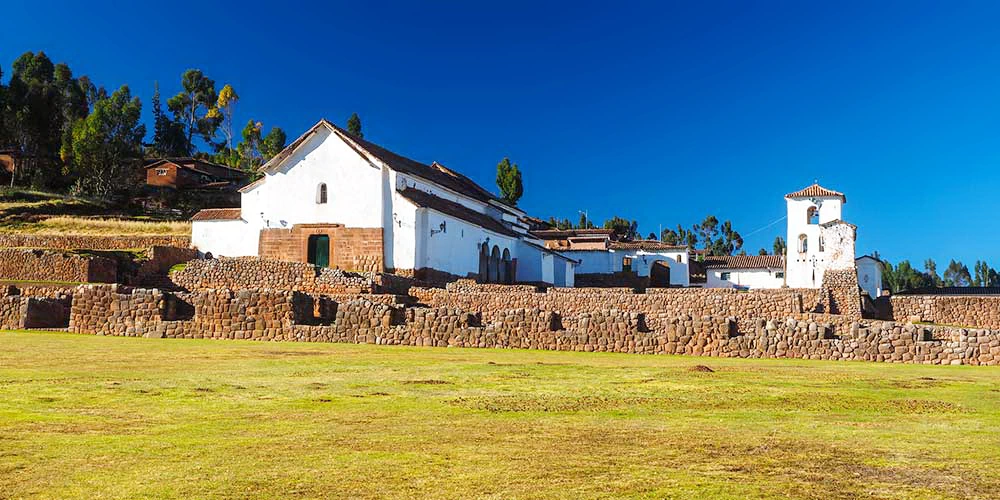 Wide view of Chinchero town with the Andes mountains in the background under a blue sky