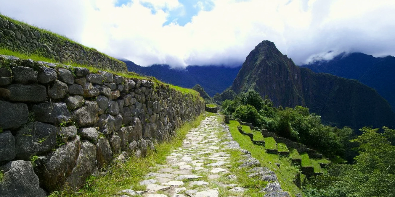 Stone path on the Inca Trail leading to a viewpoint of the Machu Picchu citadel and Huayna Picchu.
