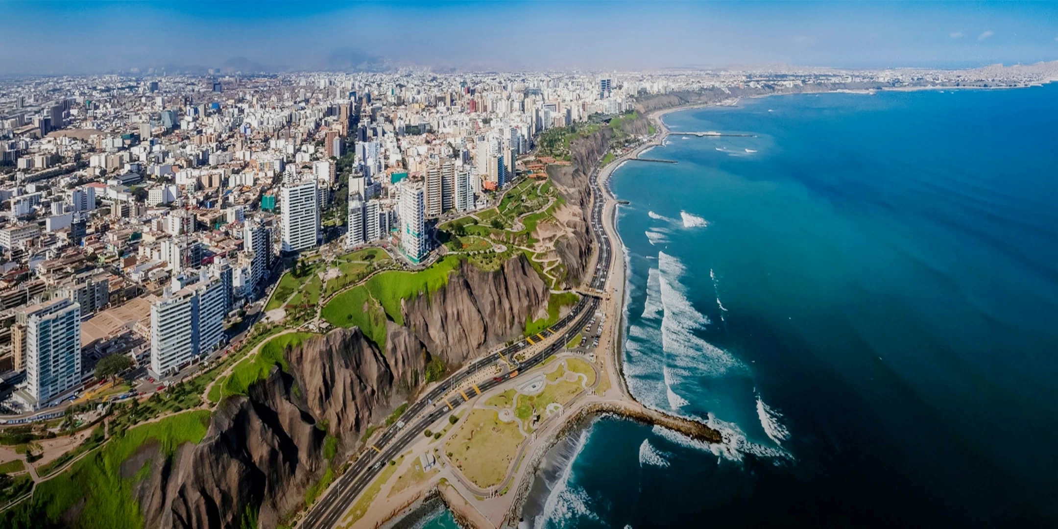 High-angle view of the Miraflores cliffs, Costa Verde highway, and the Pacific Ocean in Lima, Peru.