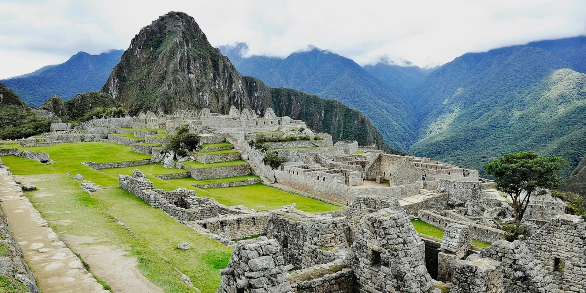 Wide view of the stone structures and green terraces of Machu Picchu ancient city.