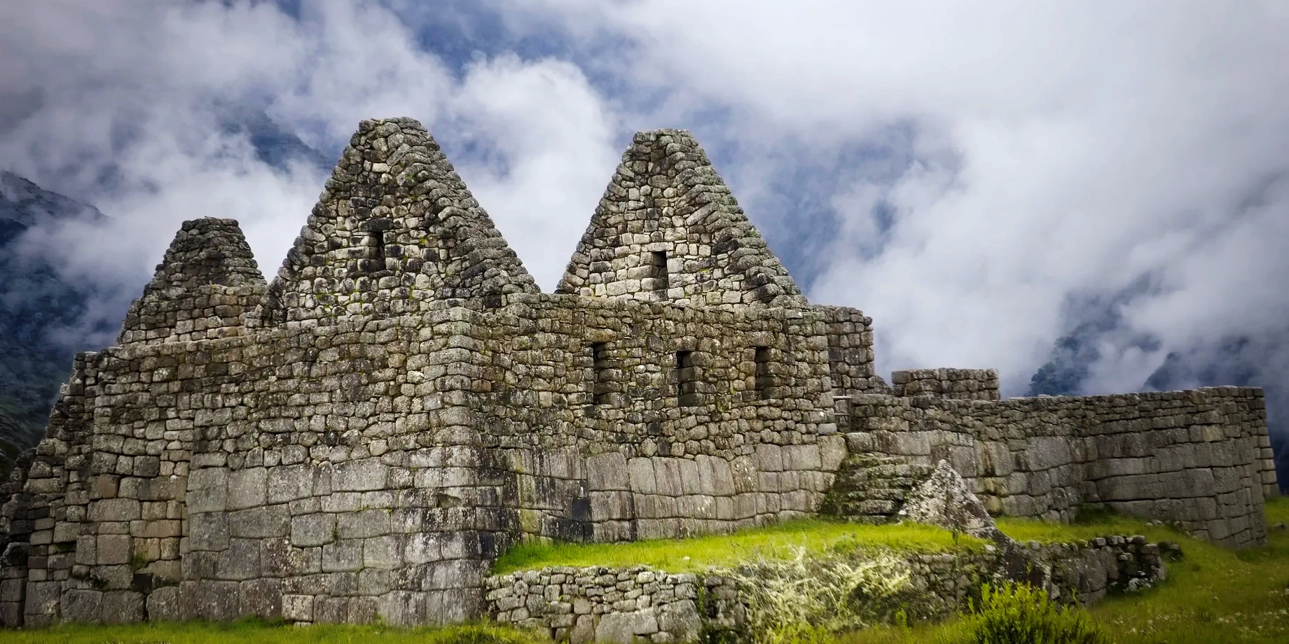 Ancient Inca stone buildings with triangular roofs at Machu Picchu ruins