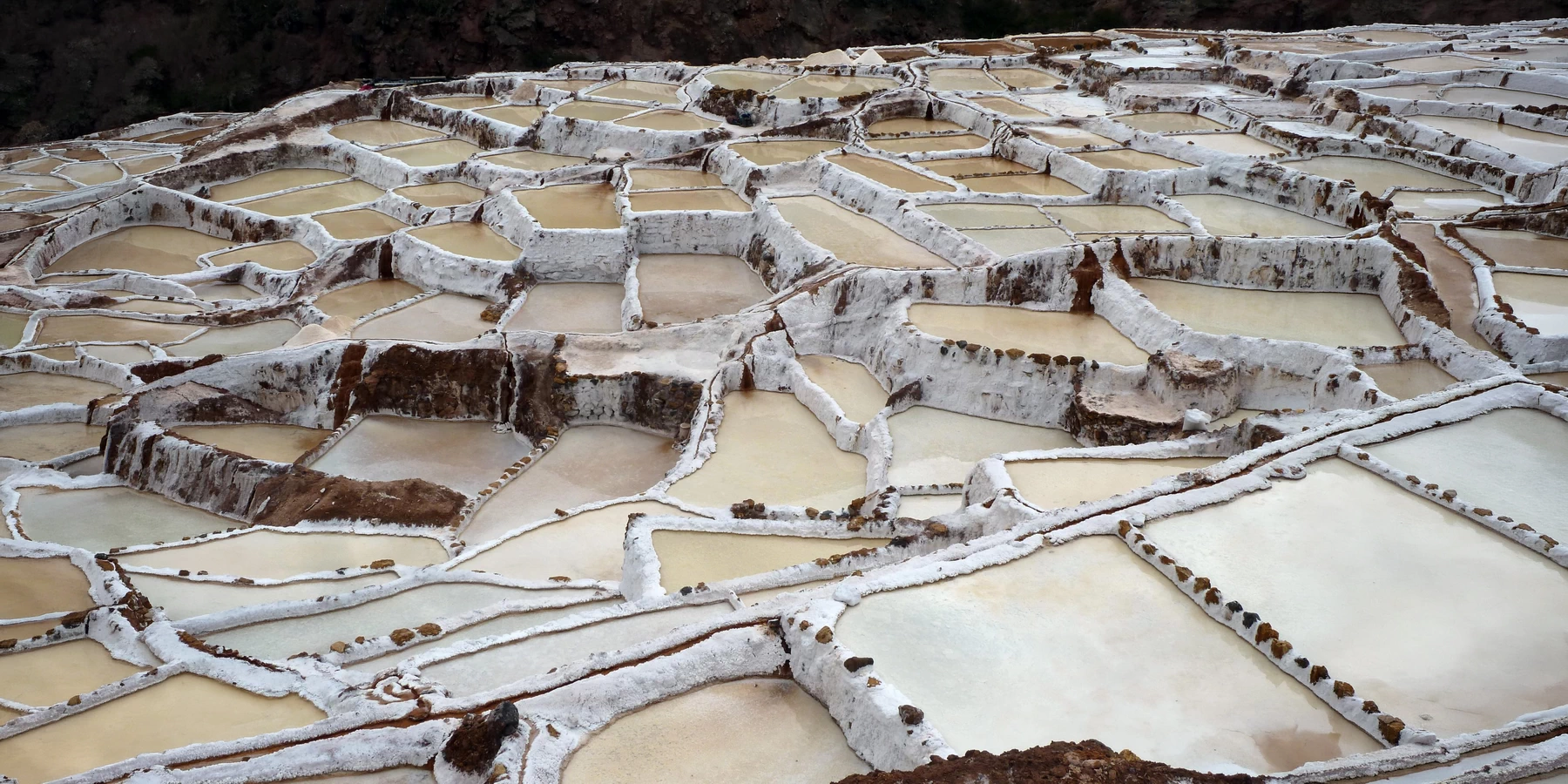 High-angle view showing the intricate pattern and texture of the salt crusts in the Maras evaporation ponds.