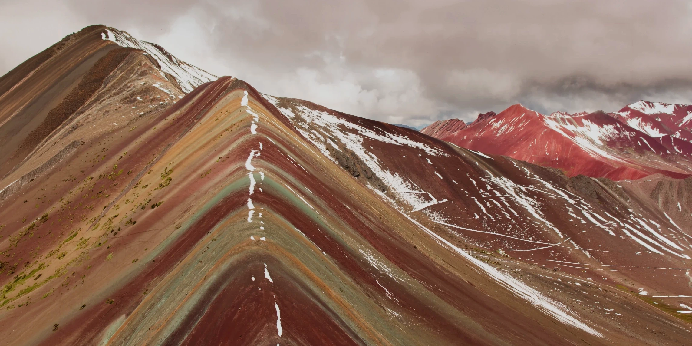 Panoramic view of the colorful mineral ridges of the Rainbow Mountain range in Peru.
