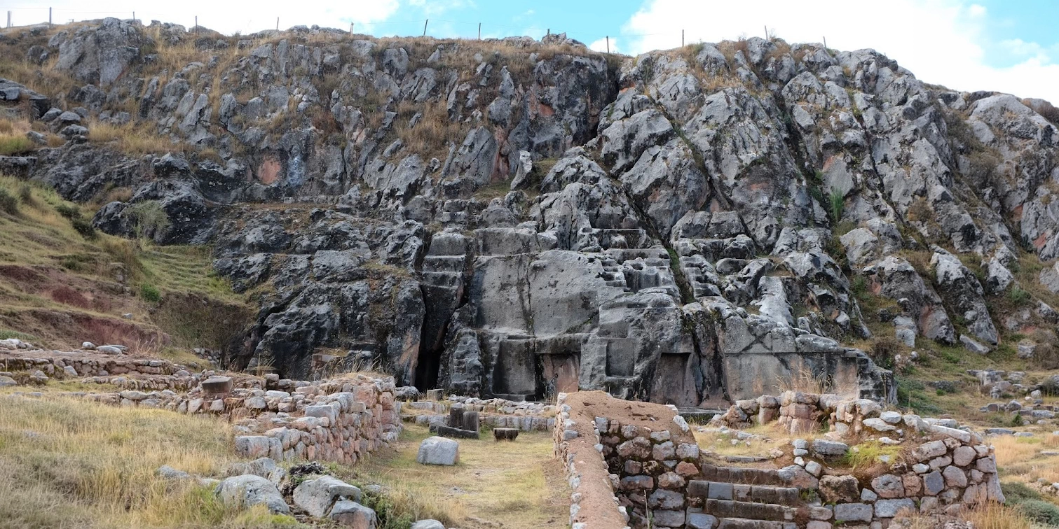 Wide shot of the massive carved limestone rock formation at Qenqo used for ancient ceremonies.