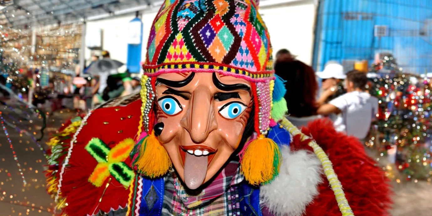 Dancer wearing a traditional Saqra mask and colorful Chullo during a festival in Cusco, Peru.
