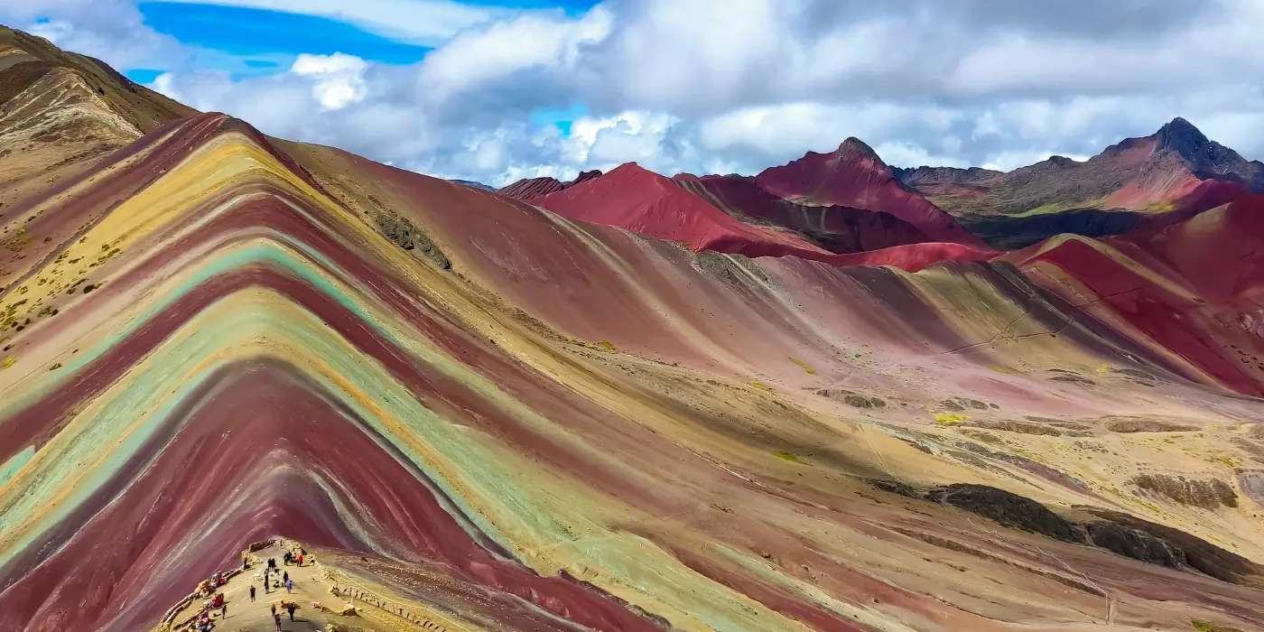 Spectacular view of Vinicunca Rainbow Mountain in Cusco, Peru, with red, green, and yellow mineral veins.