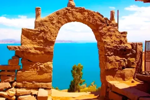 A close-up view through an ancient stone arch on Amantani Island, framing the deep blue water of Lake Titicaca.