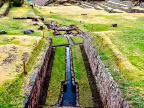 Detailed view of stone-carved irrigation channels and water systems in an Inca archaeological site.