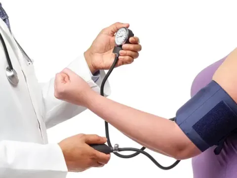 A doctor measuring a patient's blood pressure with a manual sphygmomanometer