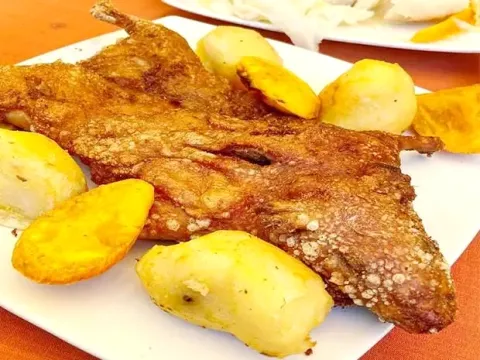 Crispy traditional Peruvian Cuy Chactado (fried guinea pig) served with boiled golden potatoes.