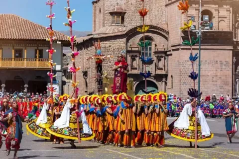 Performers in traditional Inca costumes carrying the Inca emperor through the Plaza de Armas in Cusco.