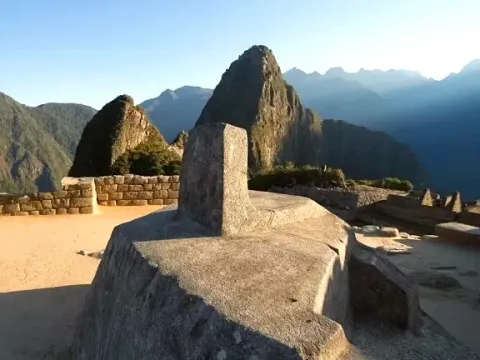 Close-up of the Intihuatana Stone, the Inca sundial in Machu Picchu, with Andean mountains in the background