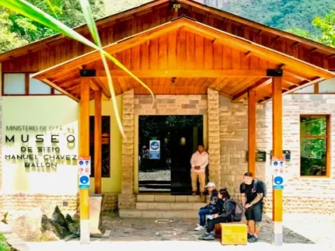 Main entrance made of wood and stone of the Manuel Chávez Ballón Site Museum with tourists waiting outside