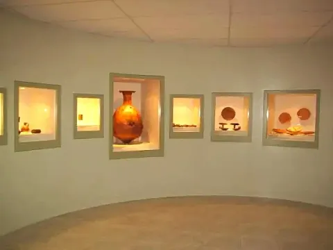 Interior of the Manuel Chávez Ballón Museum showing Inca pottery and archaeological artifacts in illuminated glass displays