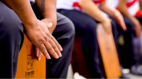 People playing the Peruvian cajon to the rhythm of Creole music. 
