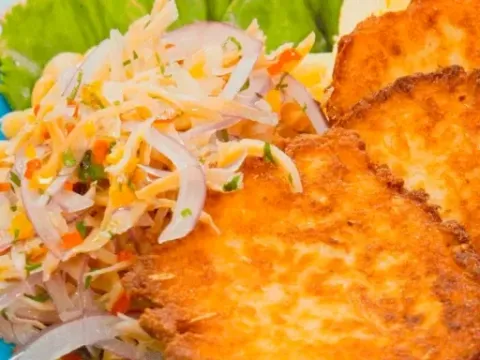 Golden crispy Peruvian corn fritters served with a fresh onion and vegetable garnish.