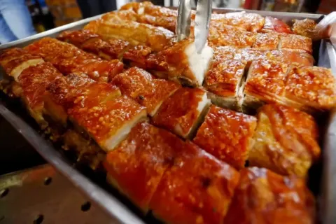 Crispy pieces of roasted suckling pig or Peruvian Lechon in a tray.