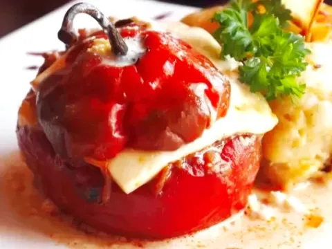 A traditional Peruvian Rocoto Relleno, a spicy red pepper stuffed with meat and topped with melted cheese.