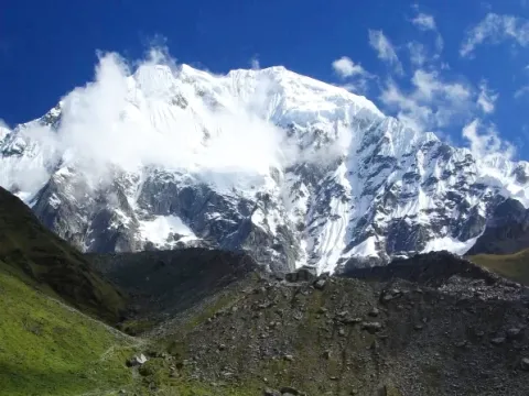 Panoramic view of the majestic snow-capped Salkantay mountain under a blue sky.