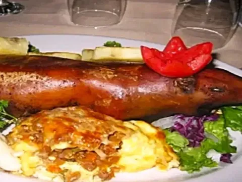 Stuffed guinea pig accompanied by a side dish of vegetables, native potatoes, and stuffed tortilla.