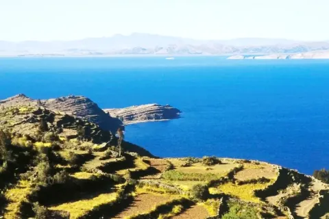 Traditional pre-Inca agricultural terraces on the slopes of Taquile Island overlooking the blue Lake Titicaca.