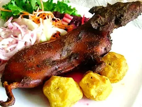 Whole baked guinea pig served with boiled native potatoes and accompanied by a traditional mixed salad.