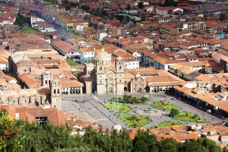 High angle perspective of the Plaza de Armas in Cusco showing the gardens, fountain, and surrounding colonial buildings.