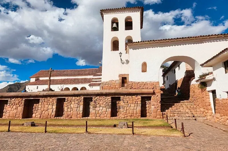 Close up of the traditional white bell tower and stone arches in Chinchero plaza
