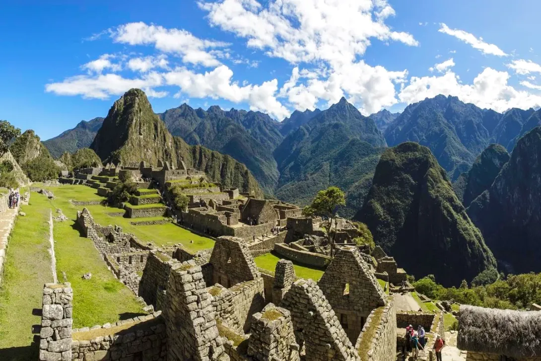 Breathtaking panoramic view of the Machu Picchu citadel with Huayna Picchu mountain in the background under a blue sky.Breathtaking panoramic view of the Machu Picchu citadel with Huayna Picchu mountain in the background under a blue sky.