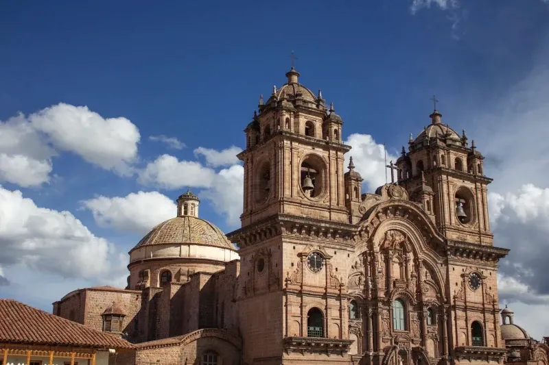 Side view of the baroque architecture and domes of a colonial church in Cusco.