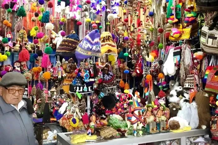 Traditional Peruvian handicrafts, colorful wool hats, and souvenirs displayed at a market stall.