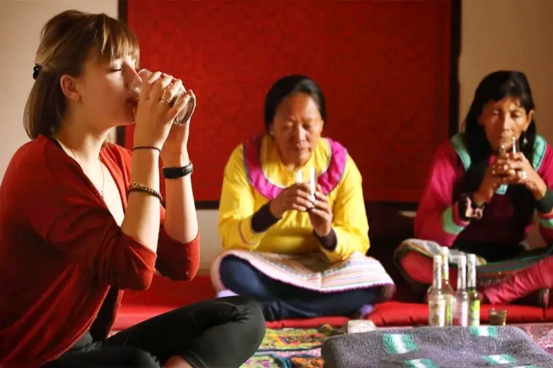 Partaking in the Ayahuasca Medicine A woman drinking sacred Ayahuasca medicine from a small glass during a traditional ceremony guided by indigenous healers.