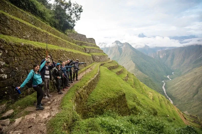 A happy group of hikers posing on the ancient agricultural terraces overlooking the Vilcanota River valley.