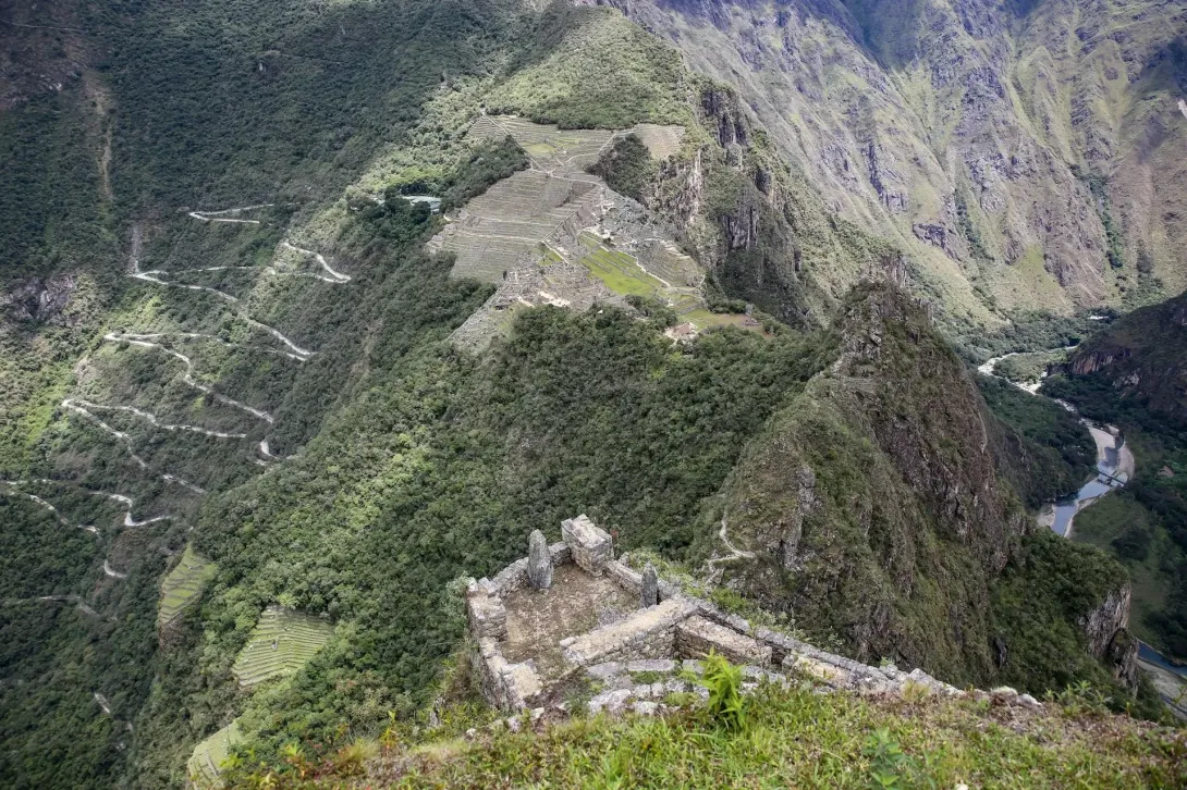 Steep stone ruins and hiking trails on Huayna Picchu mountain overlooking the Urubamba valley.