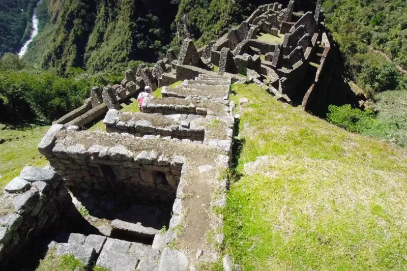 A top-down view of the impressive stone ruins and steep agricultural terraces of Wiñay Wayna along the Inca Trail.