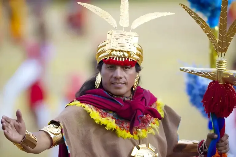 The Legacy of the Inca Empire A man portraying the Sapa Inca emperor with a golden crown and traditional Quechua regalia.