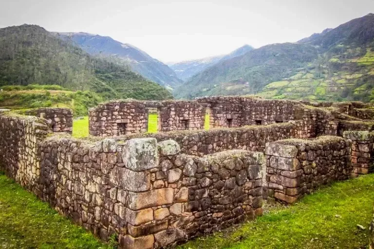Close-up of preserved Inca stone walls in Vilcabamba within a lush green valley during a trekking tour.