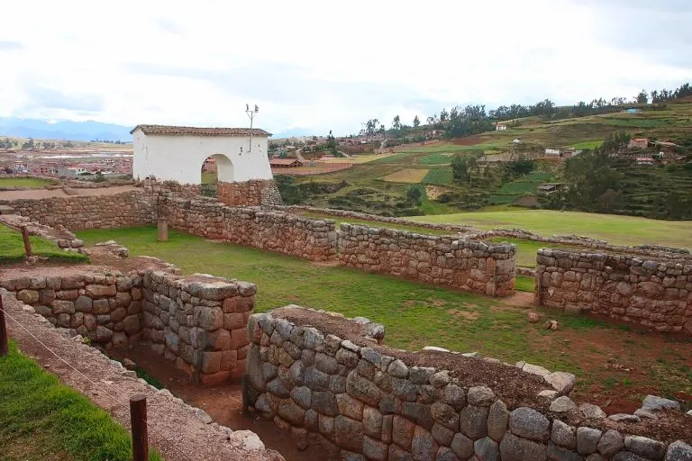 Ancient Inca stone walls and green plazas at the Chinchero archaeological complex