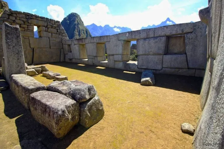 Interior view of the Temple of the Three Windows in Machu Picchu, showing the large stone blocks and the view through the windows.