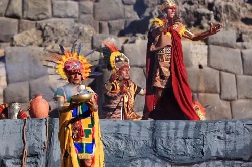 Performers representing Incan royalty performing a ceremony around a golden altar at the Sacsayhuaman stone walls.