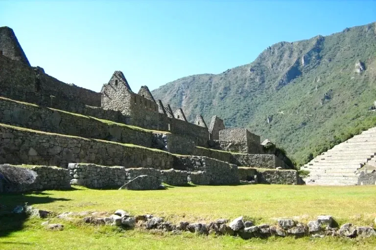 Sunny view of the agricultural terraces at Machu Picchu overlooking the steep green valley.