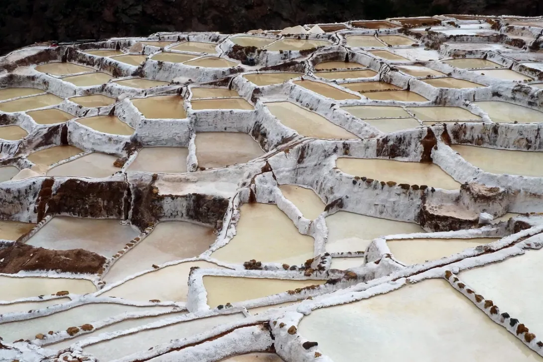 Close-up view of the white geometric salt evaporation ponds at the Maras salt mines in the Sacred Valley.