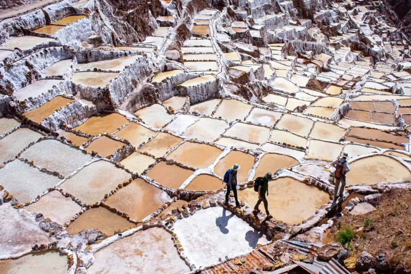 erial view of the ancient Maras salt mines with tourists walking along the ponds.