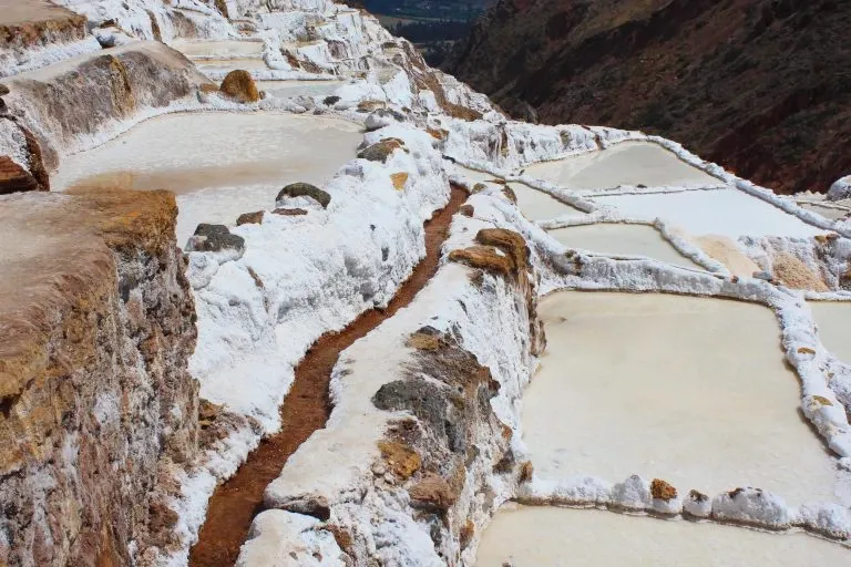 A small water channel carrying salty spring water to the different terraced levels of the Maras salt mines.