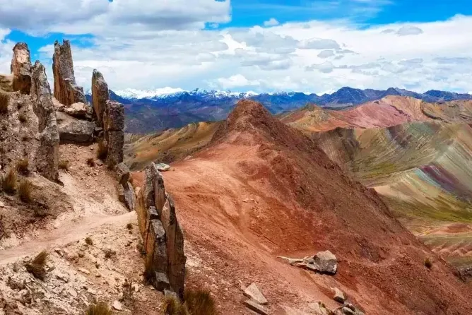 View of the natural stone forest and the multiple colorful peaks of Palcoyo Rainbow Mountain in Peru.