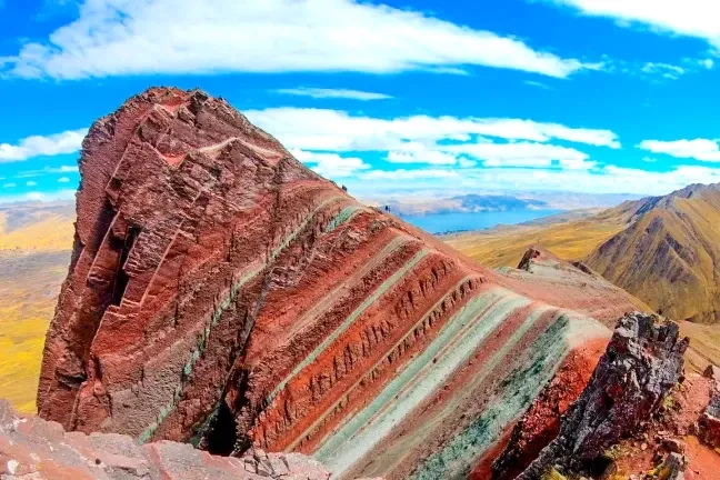 Close-up view of the unique sharp geological formations and red mineral layers of Pallay Punchu mountain.