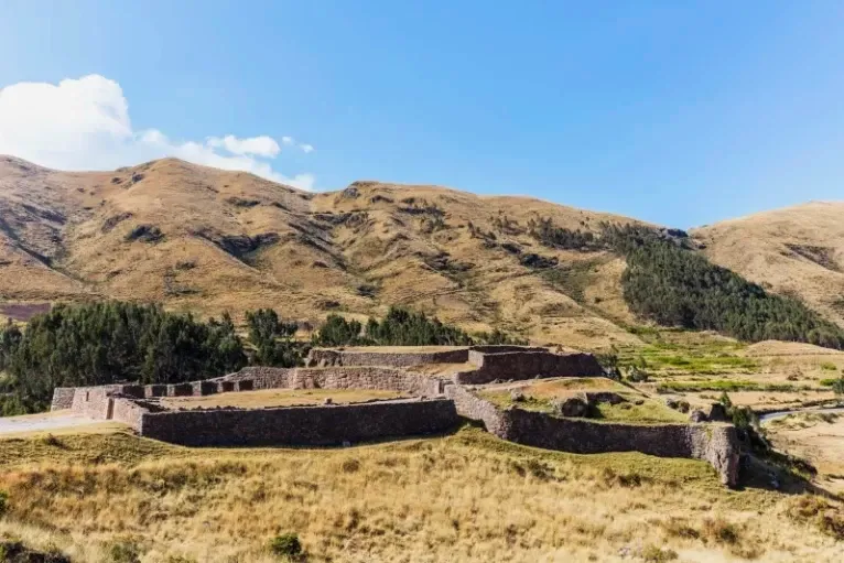 Full view of the Puca Pucara archaeological complex under a blue sky.