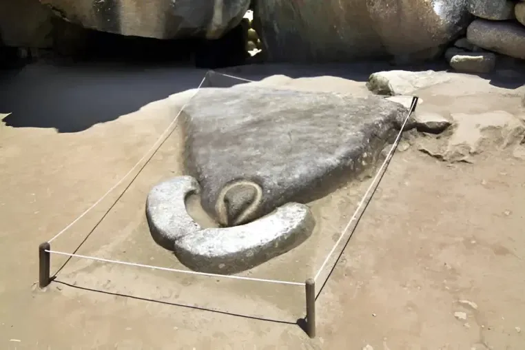 The sacred condor-shaped stone at Machu Picchu surrounded by a protective rope barrier.