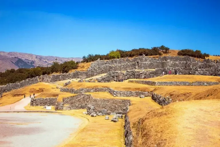 Stone walls of the Sacsayhuaman archaeological site under a blue sky in Cusco
